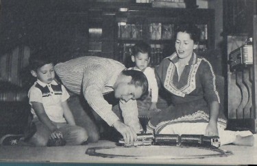 Audie Murphy plays with hsi childrens train set